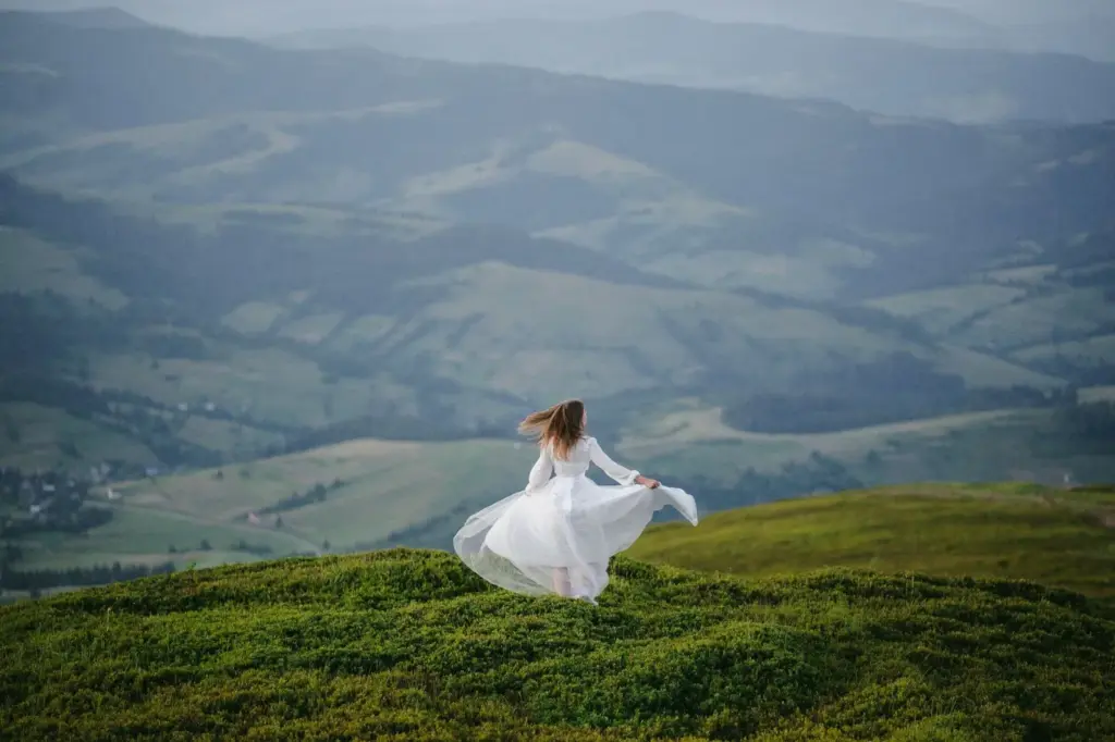 100+ Portrait Photography Ideas for Every Occasion and Style 53 Windy hilltop with flowing fabric