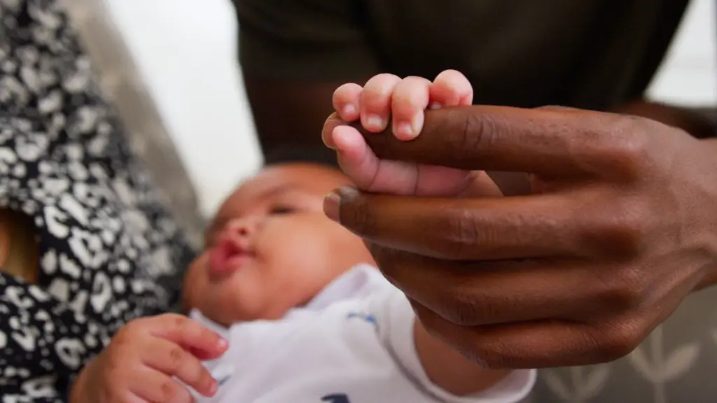 Baby holding dad’s finger