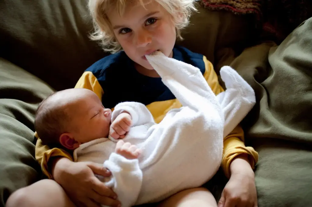 Baby on sibling’s lap