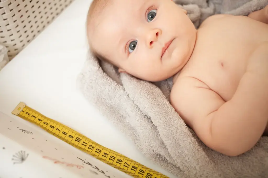 Baby posing with a growth chart
