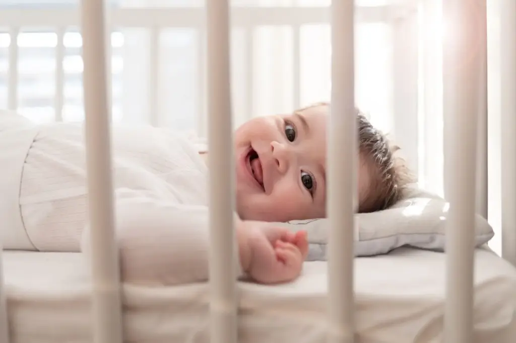 Baby smiling while sleeping in the crib