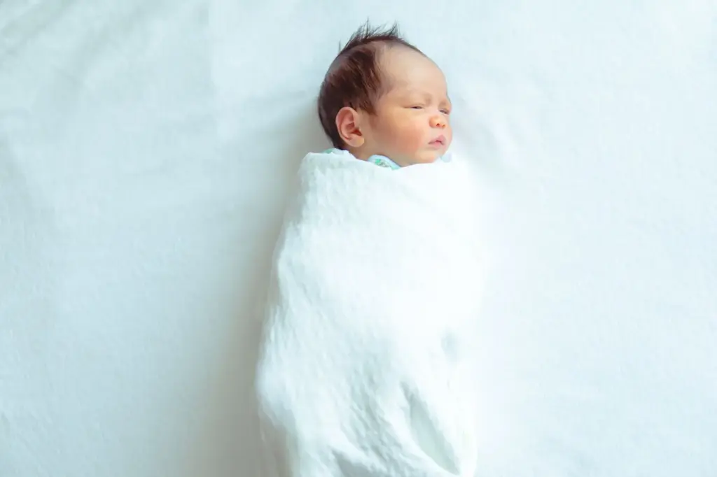 Baby wrapped in a white swaddle