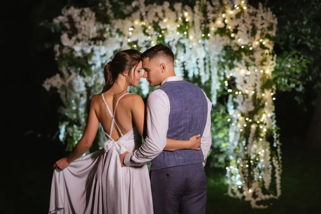 Back-to-back pose with fairy lights surrounding the frame
