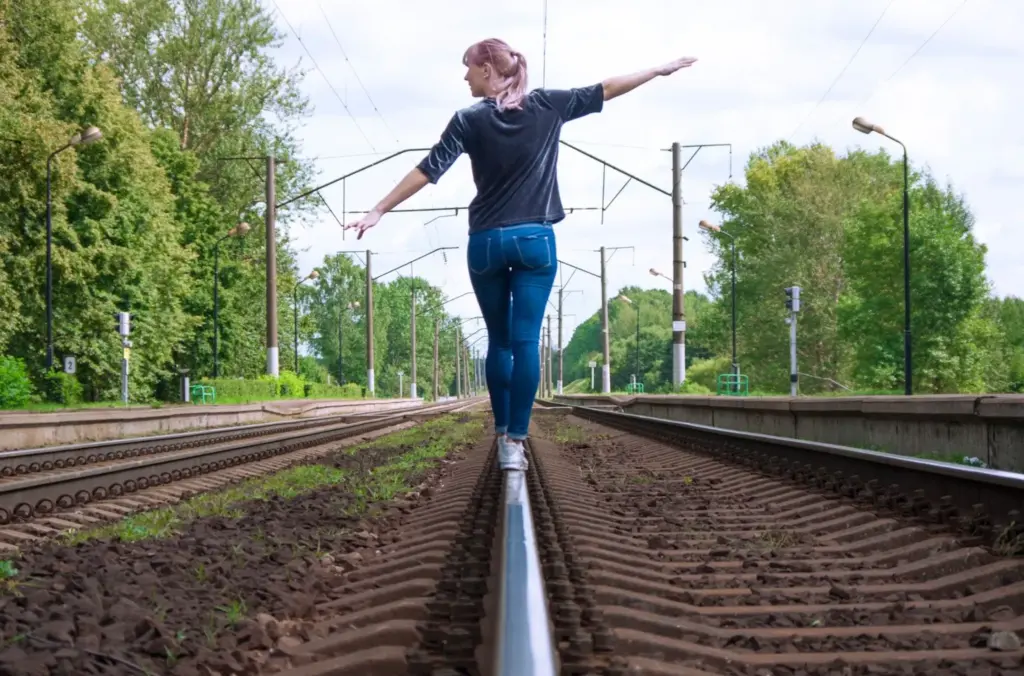 Balancing on one rail with arms outstretched