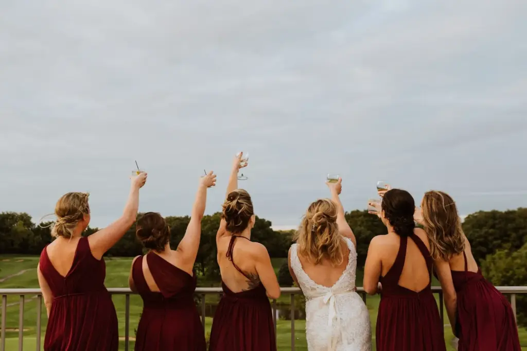 Bridal party jumping or celebrating on a hilltop