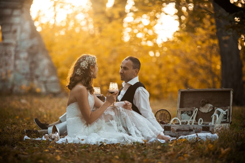 Bride and groom sipping wine on the grass