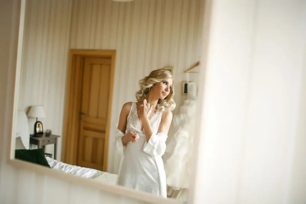 Bride fixing jewelry or applying perfume