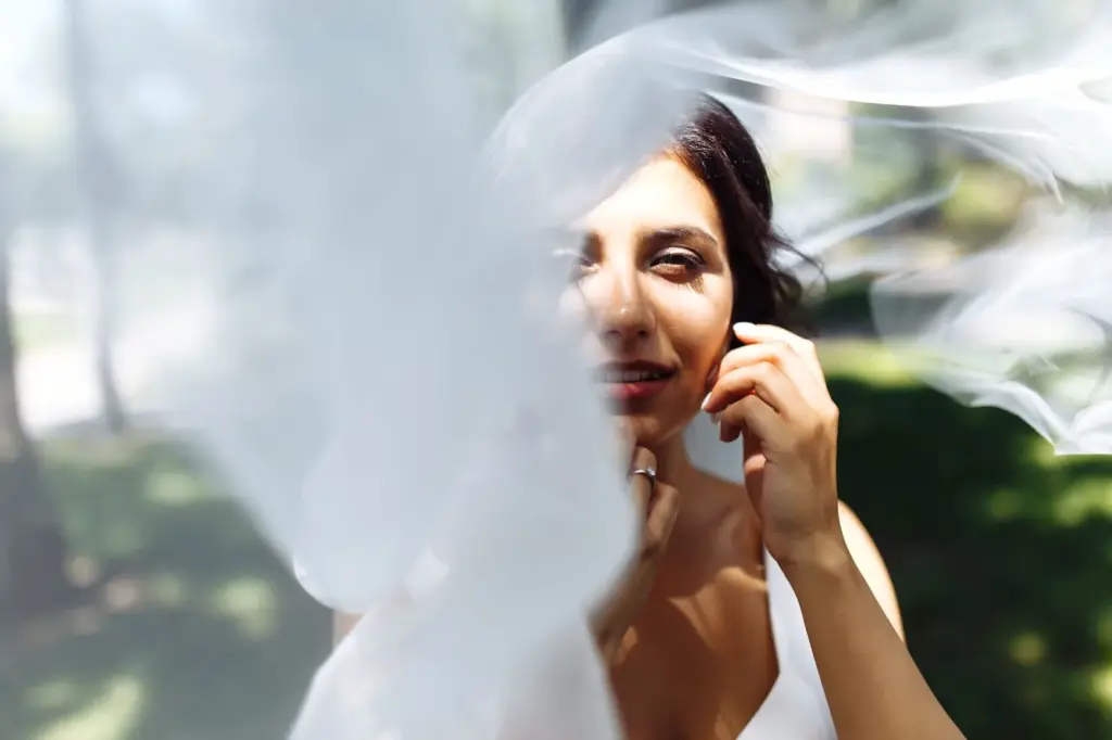Bride peeking playfully from behind the veil