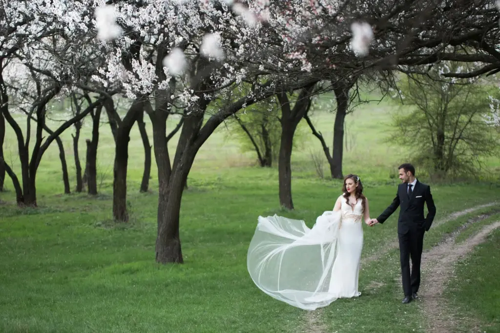Bride under a blooming tree, veil flying