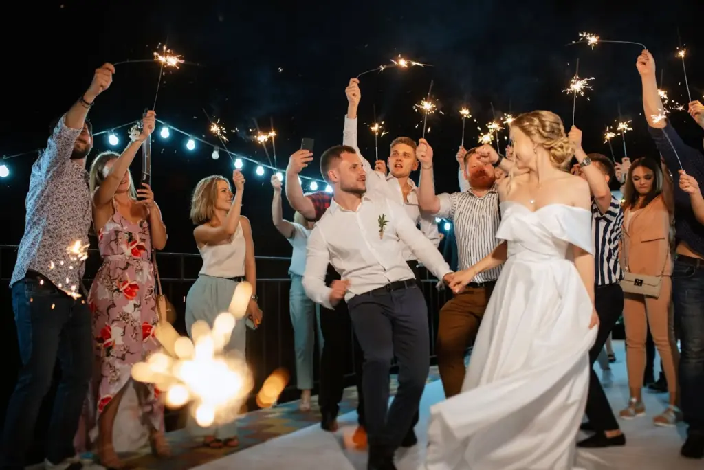Candid dancing on a barn floor under string lights