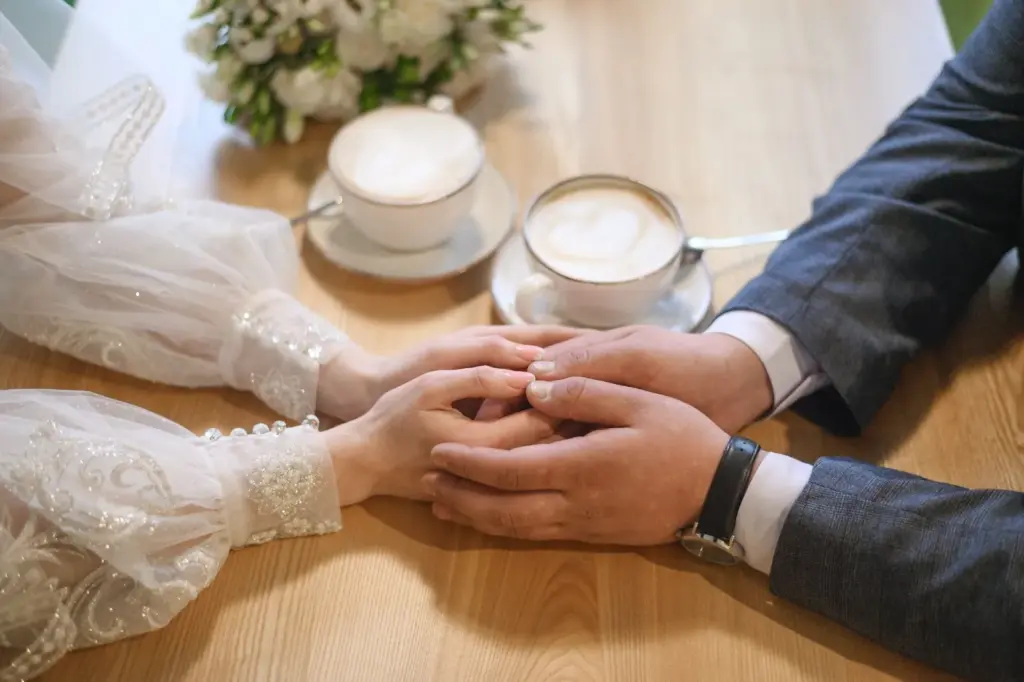 Close-up of hands holding mugs or warm drinks