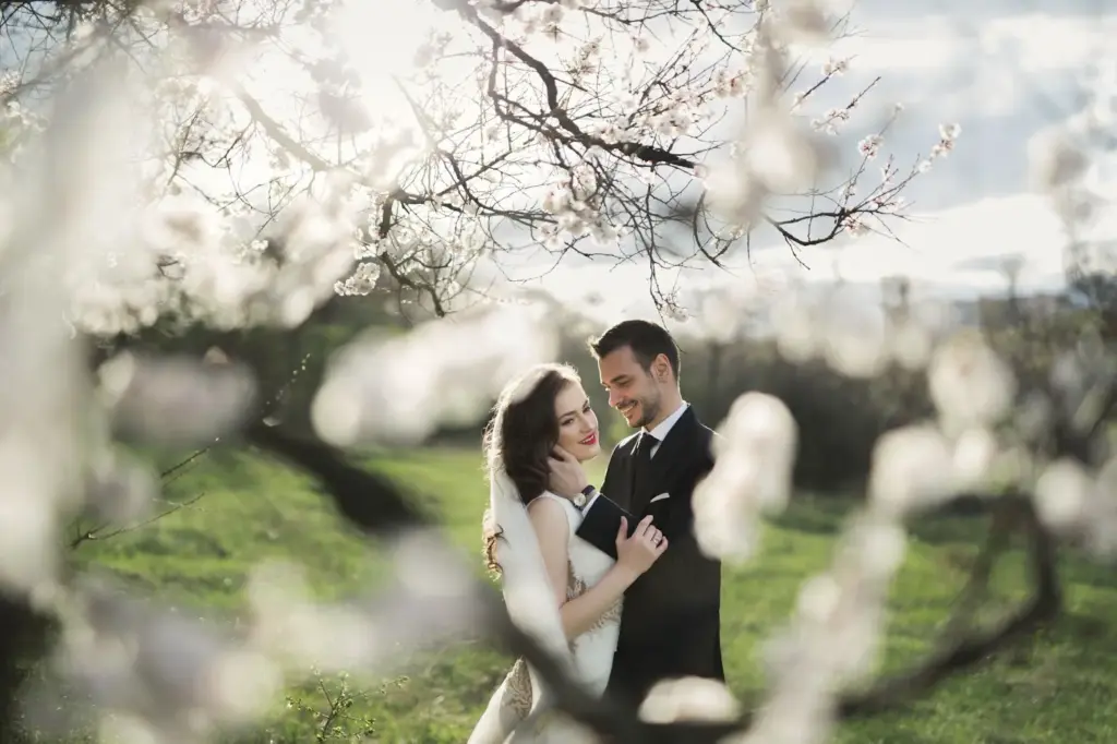 Couple captured under the arch of blossom branches