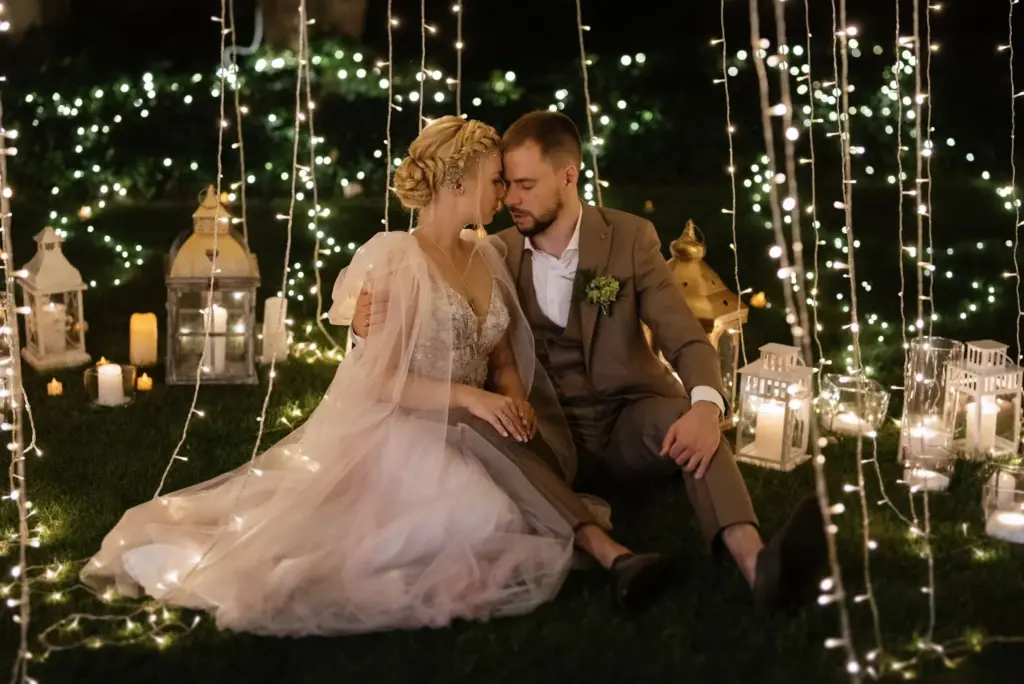 Couple forehead-to-forehead with fairy lights in the background