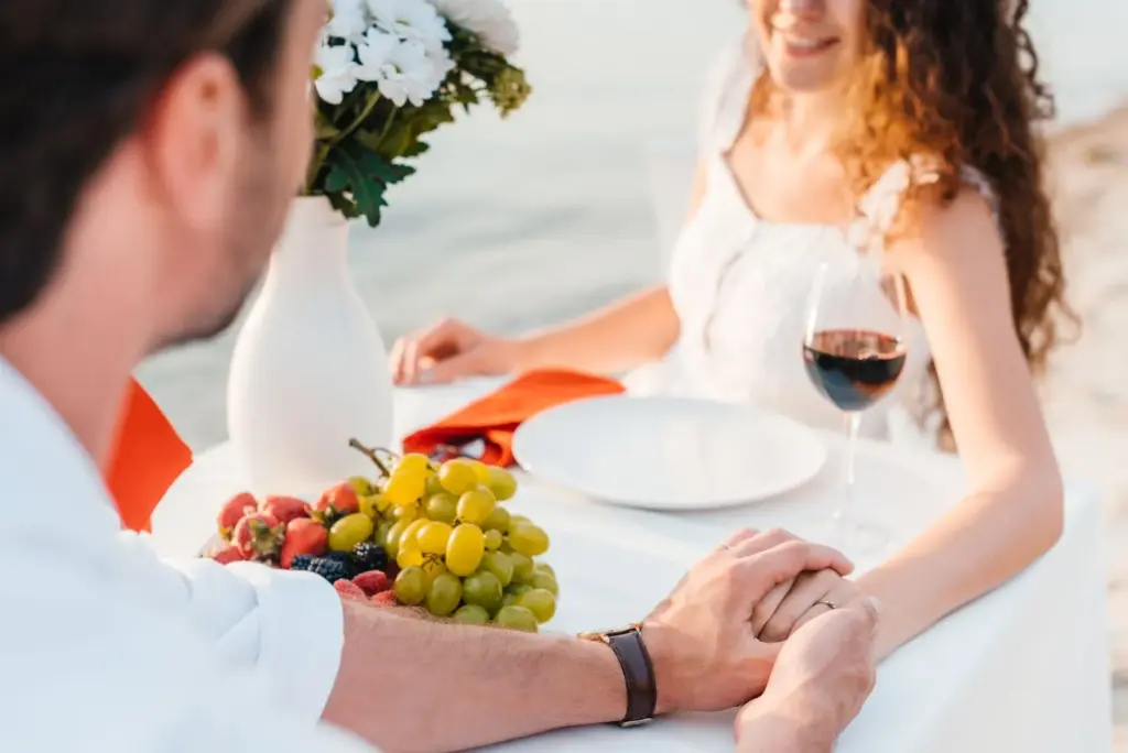 Couple holding hands across a low picnic table