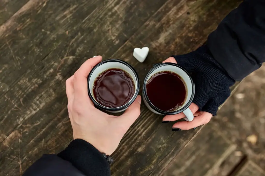 Couple holding mugs of cocoa together