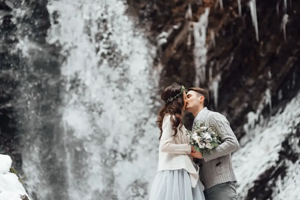 Couple kissing in front of the waterfall