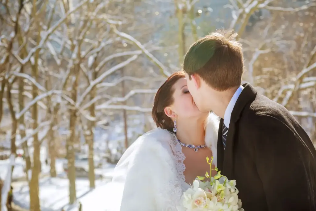 Couple kissing under fresh snow