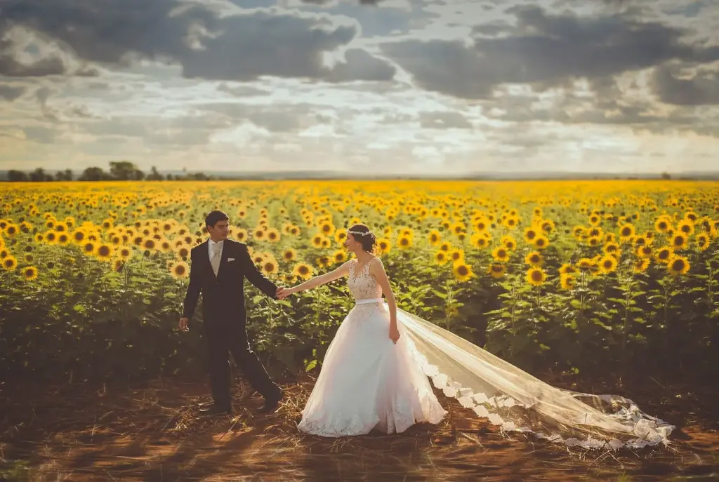 Couple laughing while walking through a sunflower field