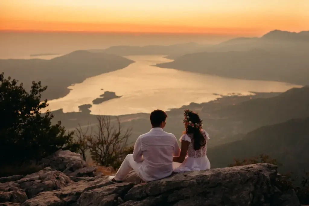 Couple sitting on a hill watching the sunset