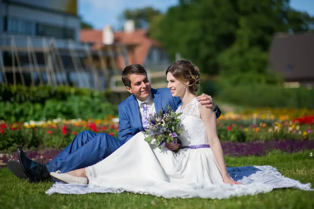 Couple sitting on grass among flowers