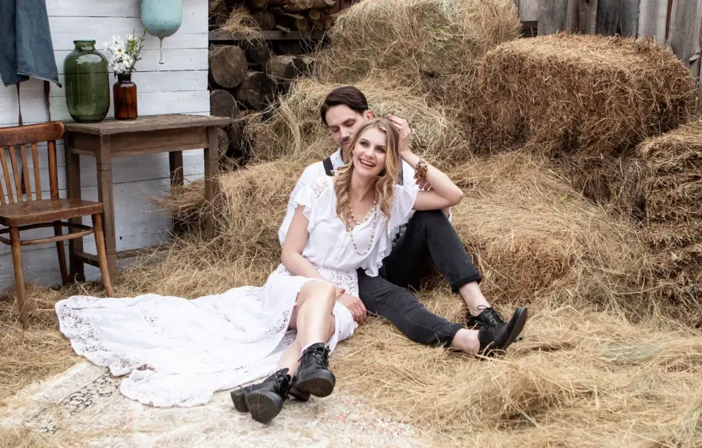 Couple sitting on hay stacks