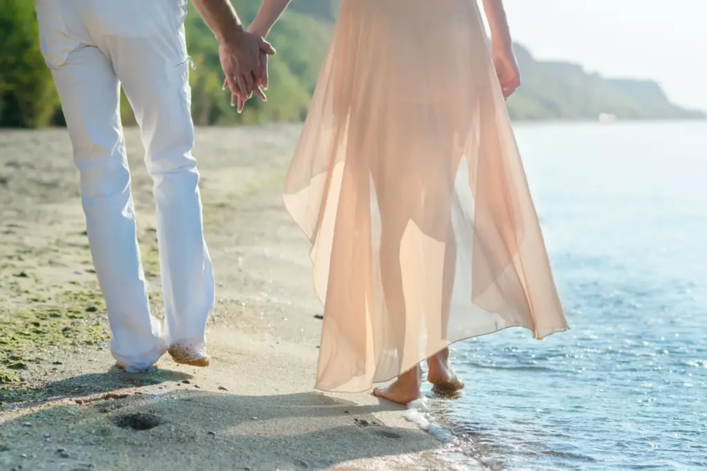 Couple walking barefoot along the shoreline