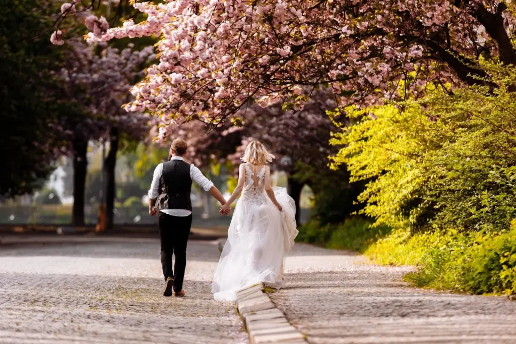 Couple walking down the blossom-covered path