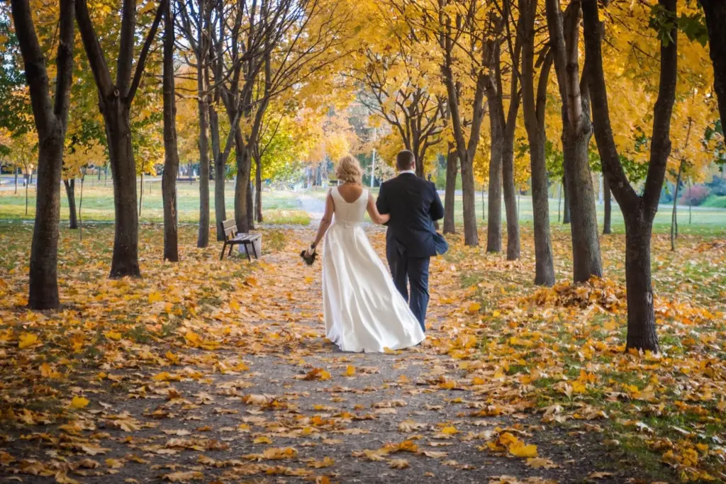 Couple walking through fallen leaves