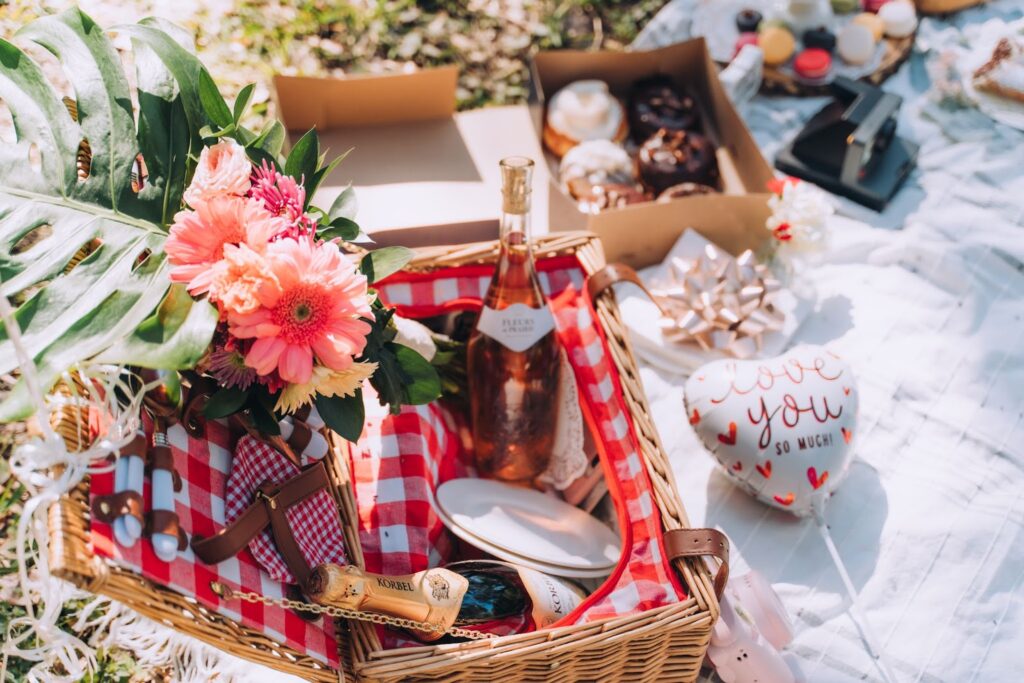 Flat lay of picnic basket, florals, and wedding details