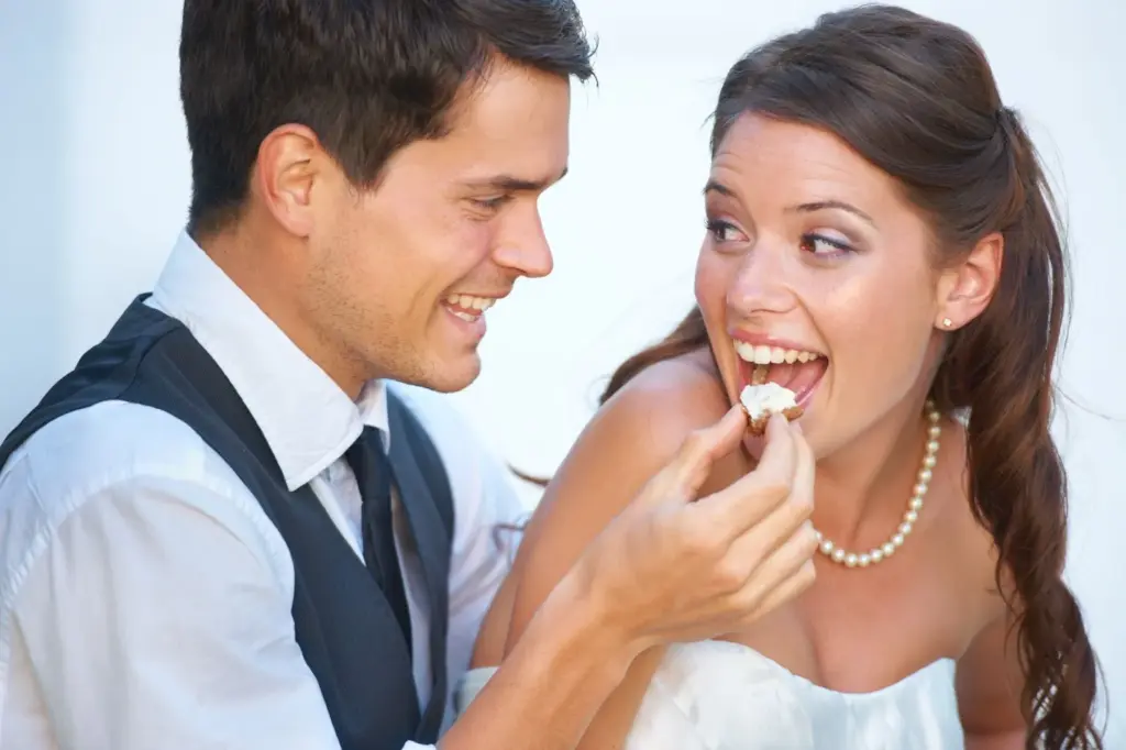Groom feeds the bride a small appetizer