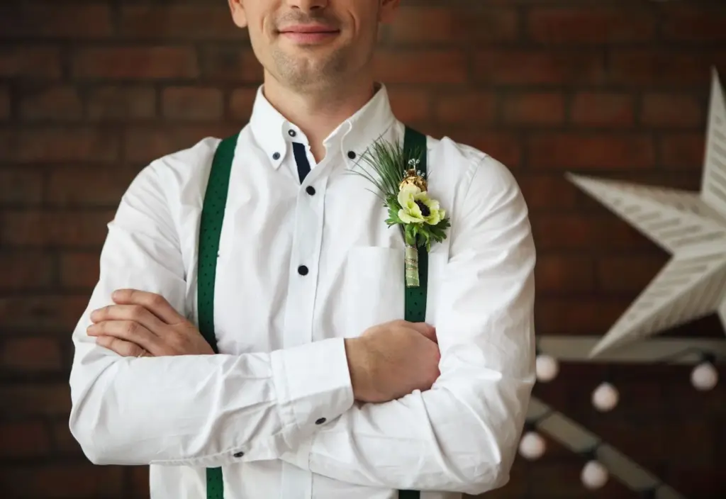 Groom in suspenders with rolled-up sleeves