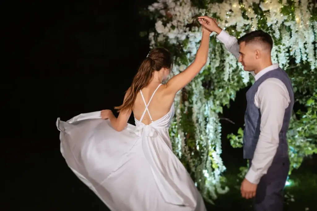 Groom twirling the bride with hanging lights
