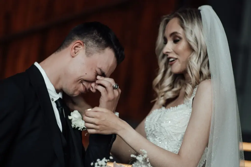 Groom wiping a tear as vows are spoken