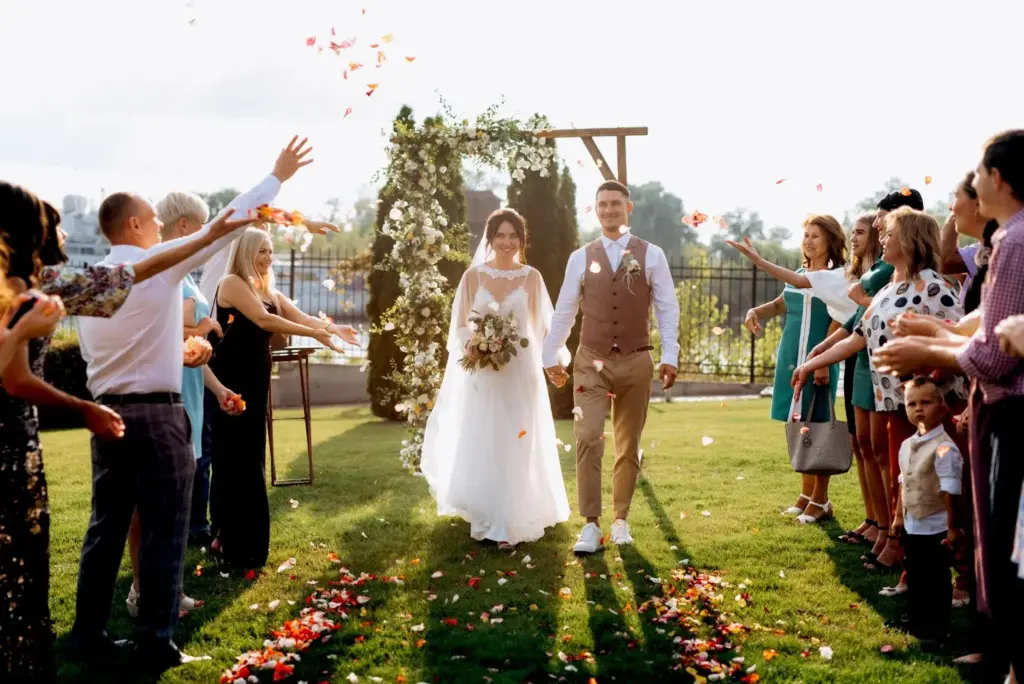 Guests throwing petals or herbs as the couple walks back up the aisle