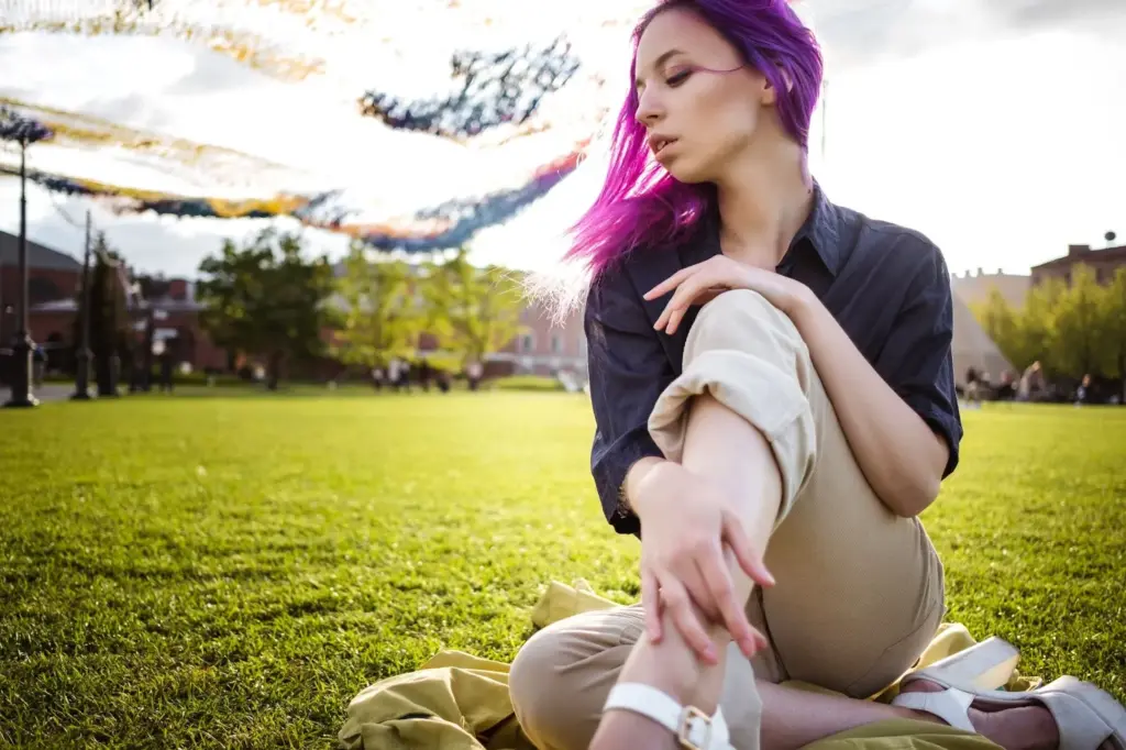 Hair blowing, kneeling on the grass