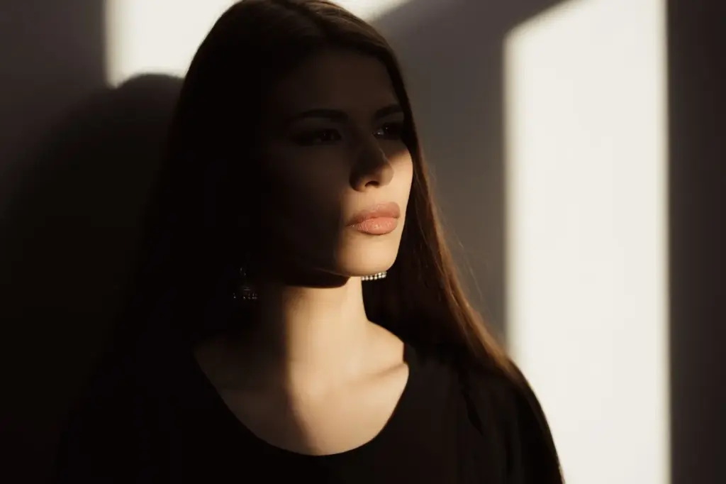 Half face in shadow, sharp expression