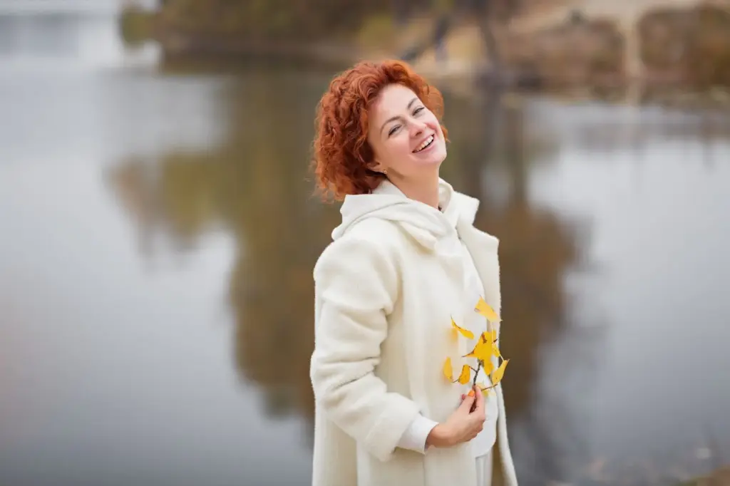Holding a flower at the lake edge