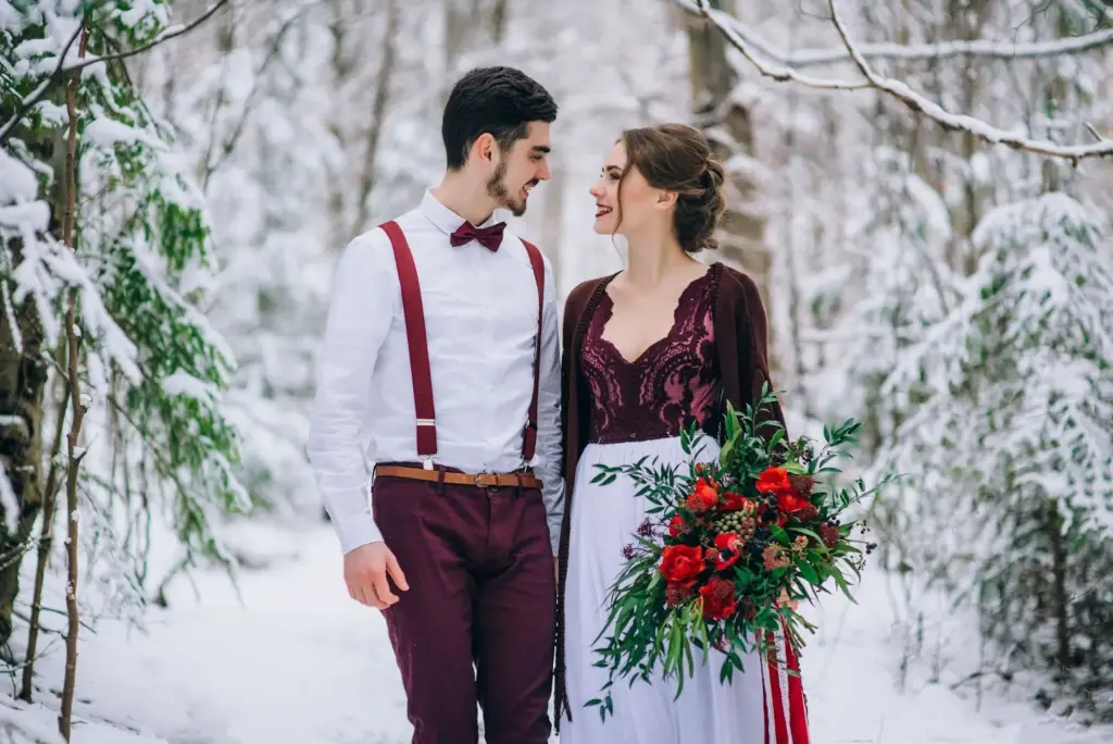 Holding hands while walking through a snowy forest