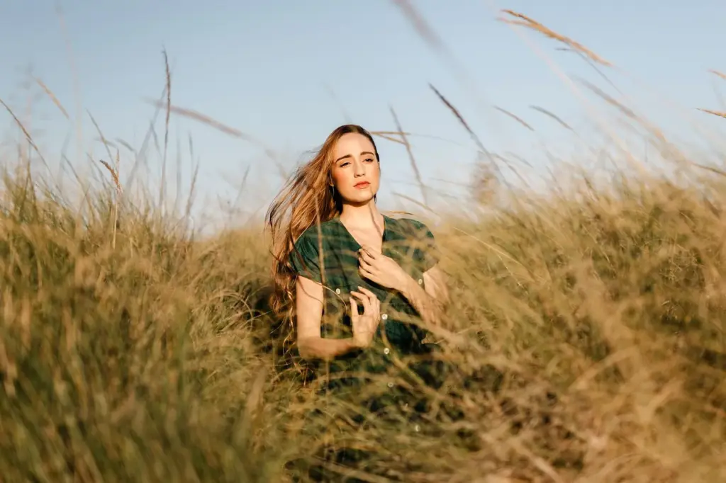 Kneeling in the grass with wind-blown hair