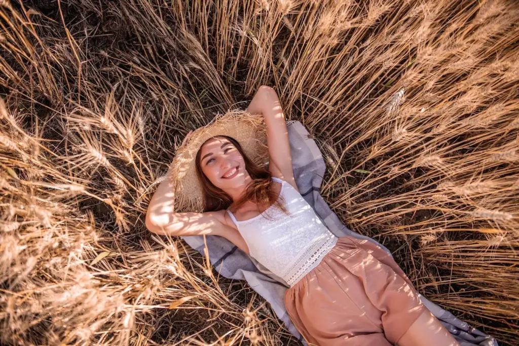 Laughing softly, lying next to tall grass