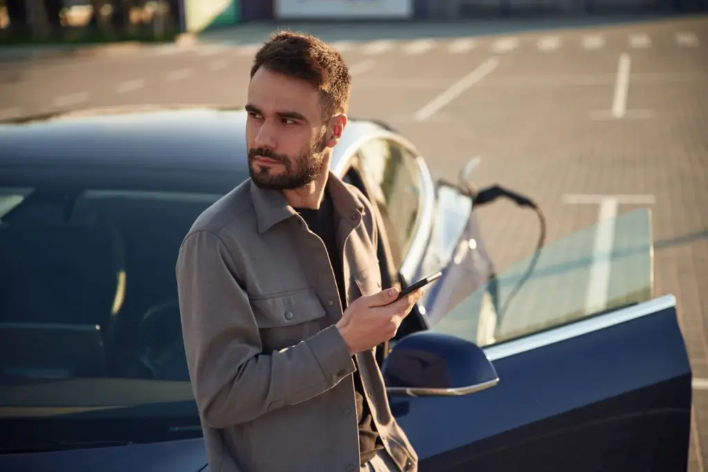 Leaning on a car in the lot