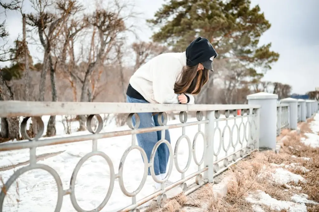 Leaning on the railing and looking down