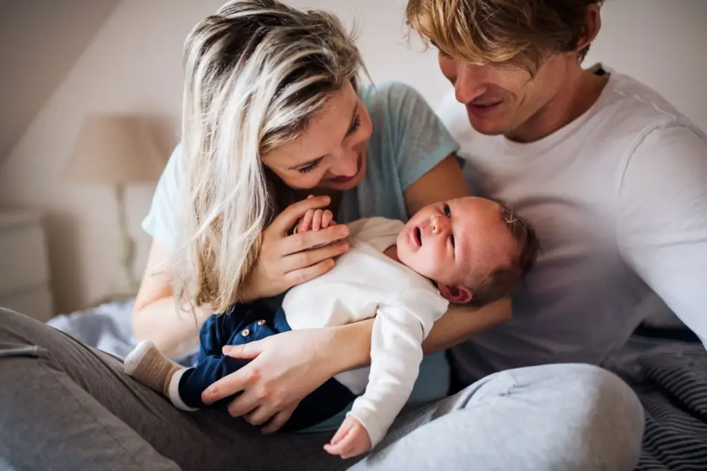 Parents laughing and doting over their newborn