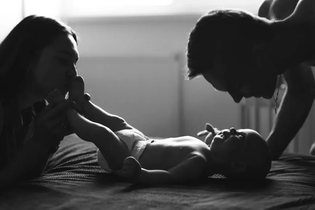 Parents playing with the baby in the shadows