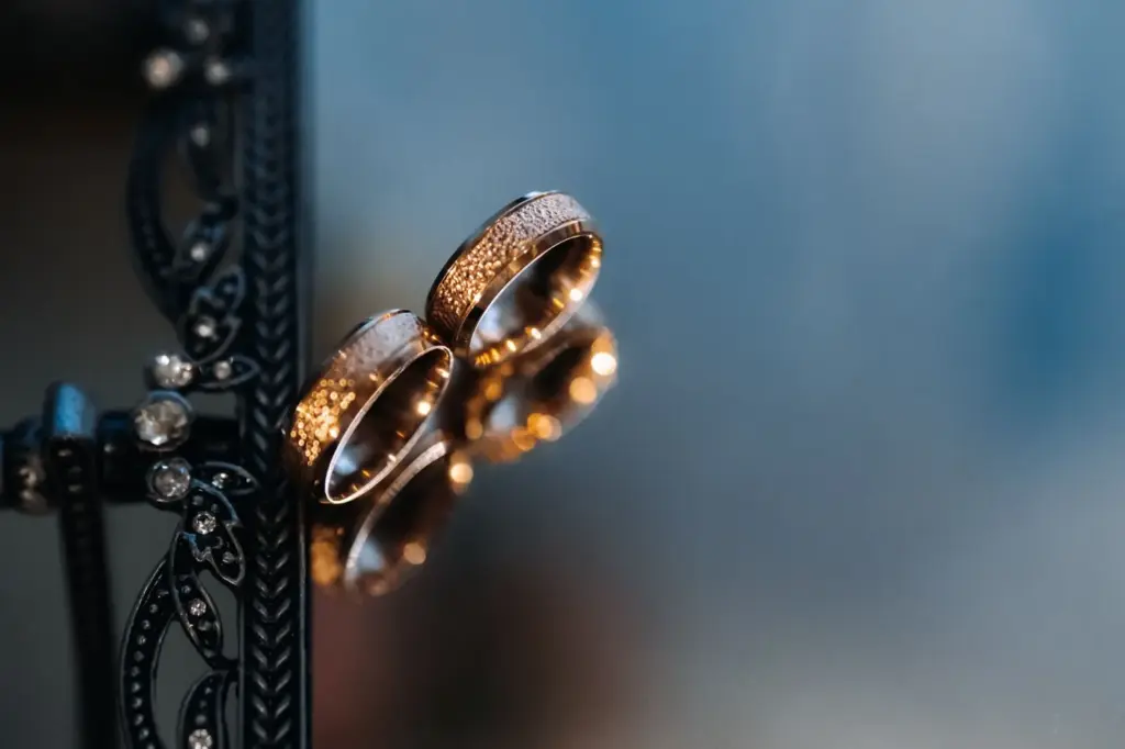 Ring detail with blurred emotional faces in the background