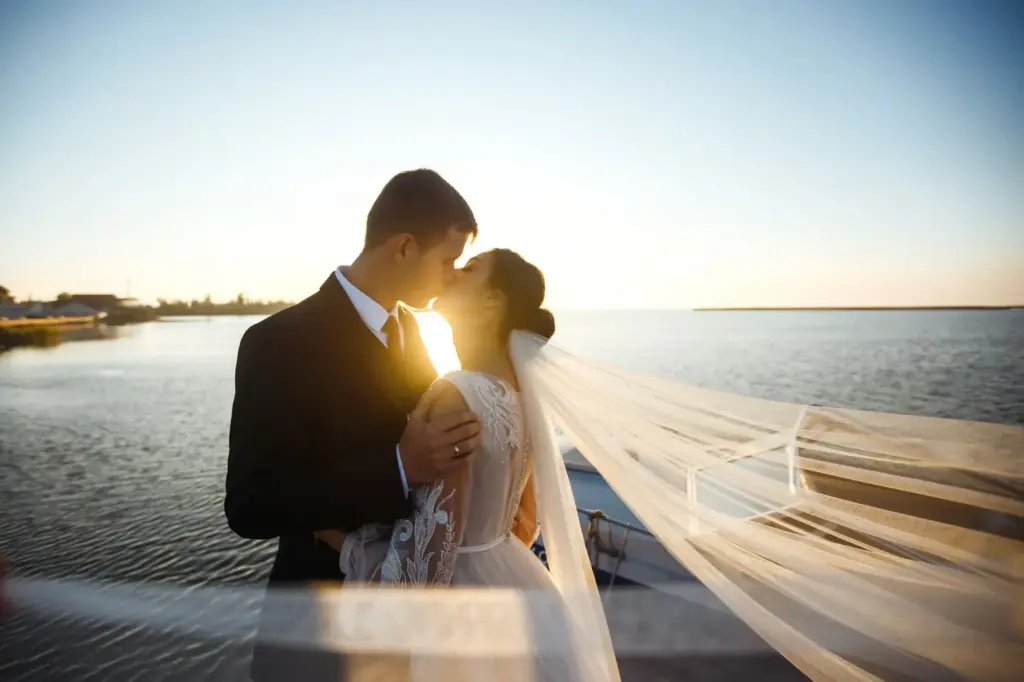 Silhouette kiss with sunset reflecting on the lake
