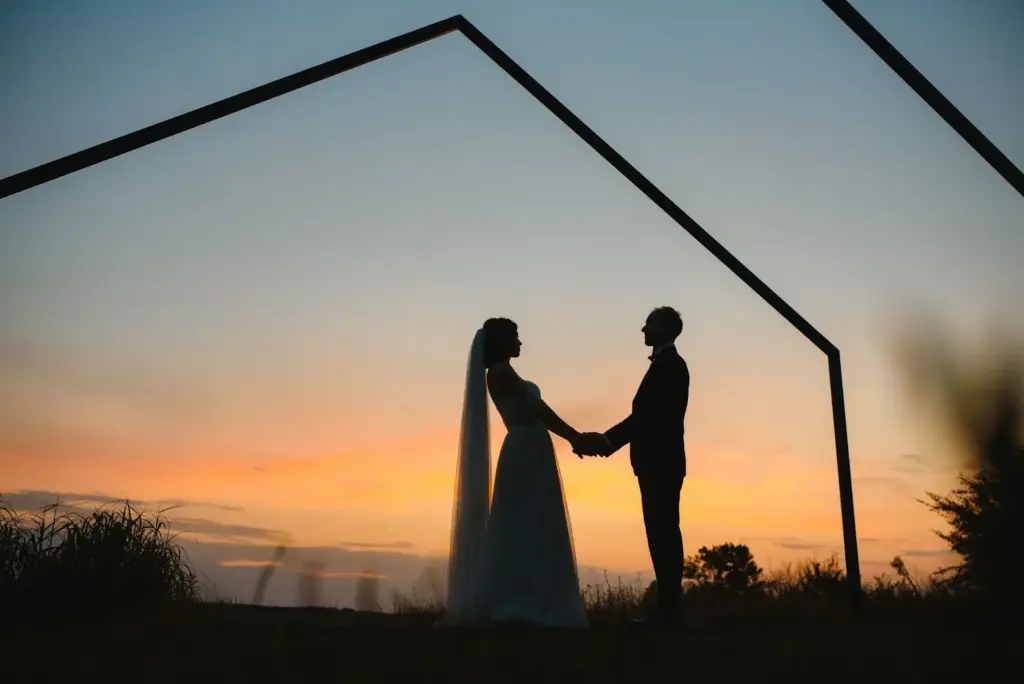Silhouette of bride and groom holding hands