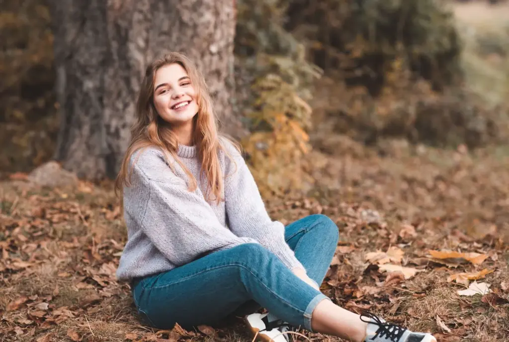 Sitting on a leaf pile and smiling