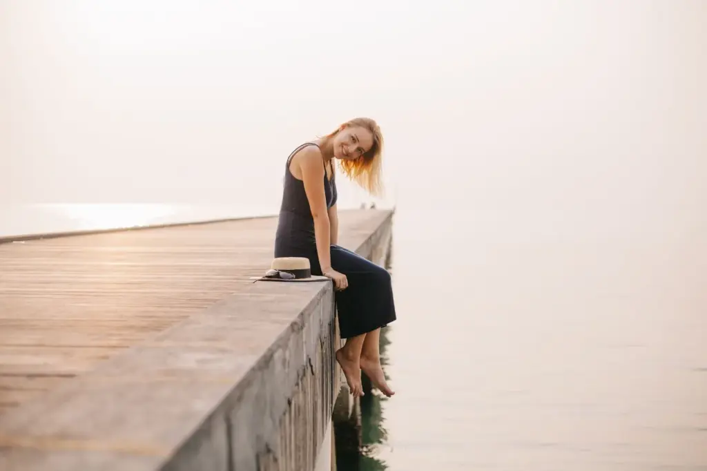 Sitting on the edge of the pier with legs dangling