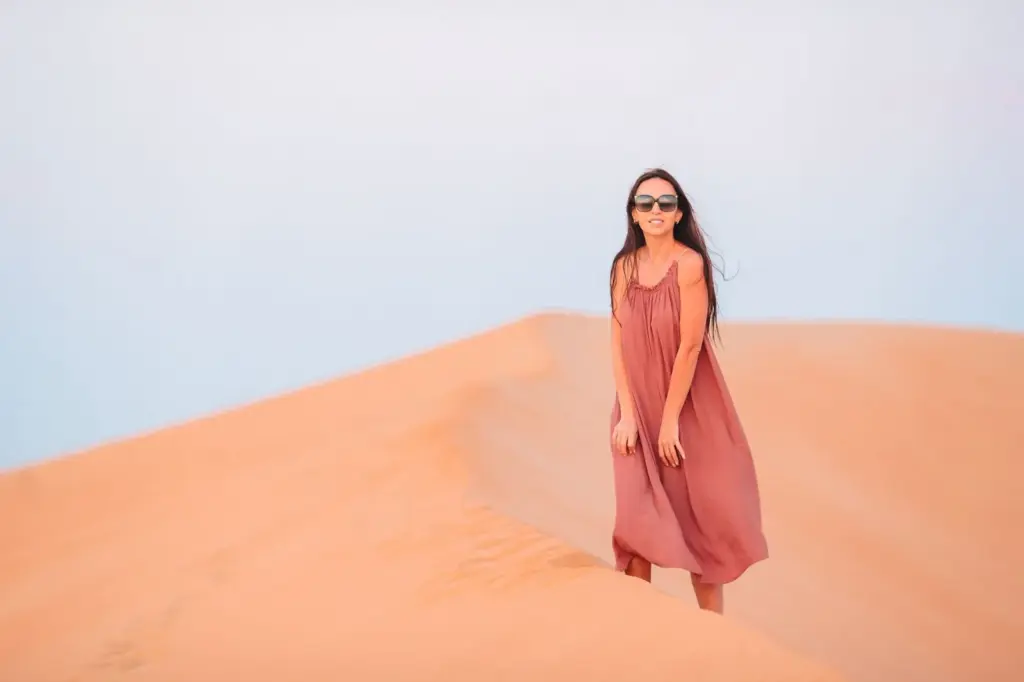 Smiling and standing on a dune